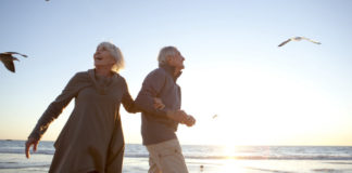 Old couple walking on the beach